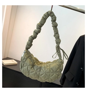 Detail of army green quilted puffer bag with ruffled shoulder strap and zip closure