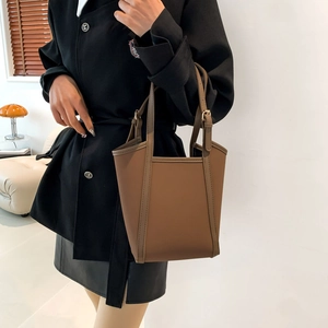 Minimalist brown PU leather bucket bag with adjustable strap and reinforced stitching