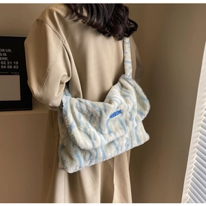 Detail of plush winter handbag featuring blue and white animal faux fur texture
