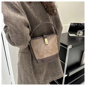 Detail der Vintage-Patchwork-Beuteltasche mit goldener Schnalle auf einem Wintermantel