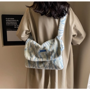 Detail view of a fluffy light blue and white striped plush crossbody bag with soft texture