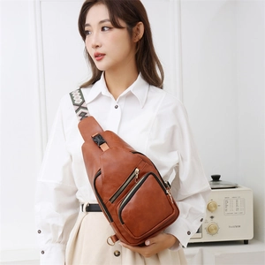 Detail of premium brown PU leather crossbody bag with ethnic jacquard woven shoulder strap