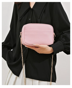 Pink lychee grain leather camera bag featuring gold chain strap and front pocket