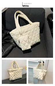 Detail view of white quilted tote bag and matching mini pouch on a grey surface