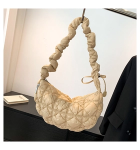 Detail of quilted champagne handbag with ruched strap and puffy cloud texture