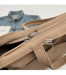 Detailed macro of smooth silver zipper hardware on a corduroy textured tote bag