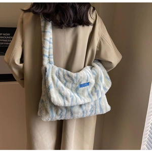 Detail shot of blue and white zebra pattern plush crossbody bag worn by a model