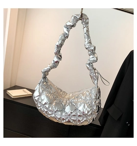 Close-up of silver quilted hobo bag with unique scrunchie shoulder strap and metallic finish