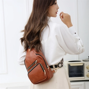 Brown leather crossbody bag with geometric woven strap and multiple zipper pockets