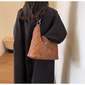 Detailed view of brown quilted PU shoulder bag with silver turn-lock and vintage texture