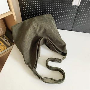 Dettaglio della borsa a tracolla in velluto a coste verde scuro con fibbia argento