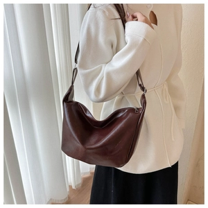 Close-up of a vintage dark brown PU leather hobo bag worn on a shoulder