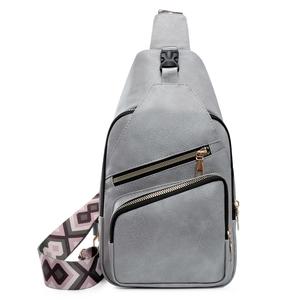 Detail of grey PU leather crossbody bag with three zippers and colorful woven strap