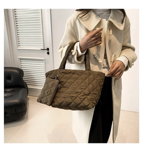 Detail of coffee brown quilted tote bag with matching zipper pouch on model in coat