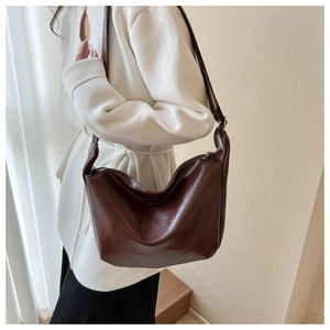 Detail of dark brown glossy PU leather hobo bag showing texture and stylish shoulder strap