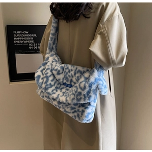 Detail showing plush blue and white leopard print crossbody bag with soft faux fur texture