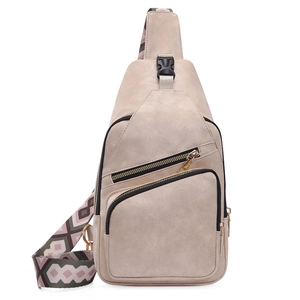 Detail of beige PU leather crossbody bag with bohemian patterned strap and gold zippers