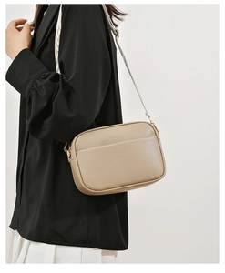 Detail of taupe crossbody bag with lychee texture and geometric pattern shoulder strap