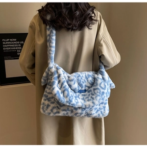 Detailed close-up of blue and white leopard print plush tote bag with a wide shoulder strap