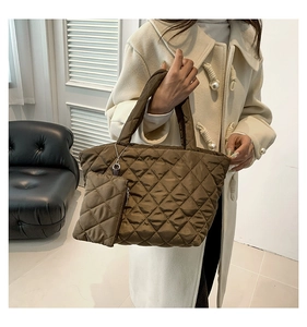Detail of a brown quilted nylon handbag with soft texture and matching mini zip pouch