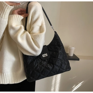 Close-up of black quilted shoulder bag featuring a silver twist lock and luxury texture