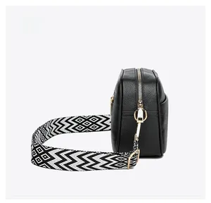 Side view of black lychee grain leather camera bag with geometric wave strap