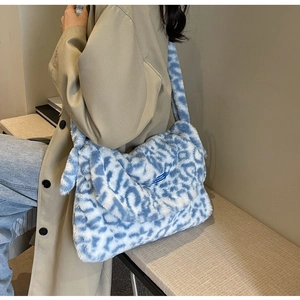 Detail showing plush blue and white leopard print fabric texture on a soft shoulder bag
