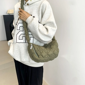 Minimalist green quilted puffer bag with wide strap for casual street style wear