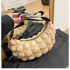 Dettaglio borsa a nuvola in nylon trapuntato albicocca con tracolla e texture a pieghe