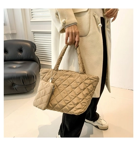 Close-up of beige quilted cotton handbag with matching small pouch and classic diamond pattern