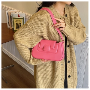 Detail of a pink leather shoulder bag with a matte finish and square buckle decoration