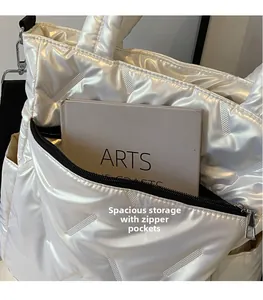 Detail of pearlescent quilted tote bag showing a large functional zipper pocket for storage