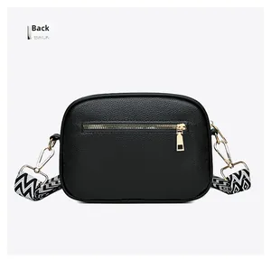 Detailed back view of a black lychee leather crossbody bag with a gold zipper pocket