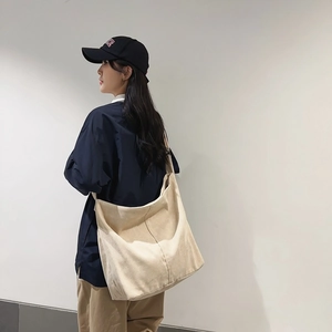Dettaglio della borsa a tracolla beige in velluto a coste con grande capacità e trama