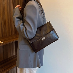 Minimalist black glossy PU leather tote bag with metal chain strap and turn-lock closure