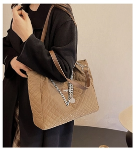 Détail du sac cabas en nylon matelassé marron avec chaîne argentée et poignée en cuir