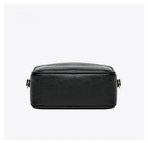 Macro view of bottom structure and D-ring hardware on black pebble leather camera bag
