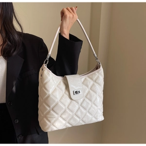 Detail shot of white quilted hobo bag featuring shiny oil wax PU leather and silver clasp