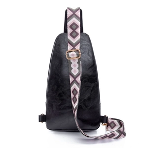 Close-up of black PU leather crossbody bag with wide geometric pattern woven strap