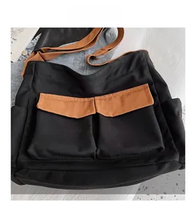 Detailed view of canvas messenger bag featuring dual front pockets and contrast flap