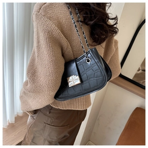 Detail of black crocodile embossed faux leather shoulder bag with silver chain strap