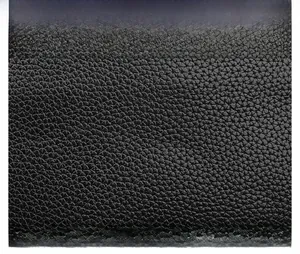 Detailed macro view showing high-quality black lychee grain texture on leather camera bag