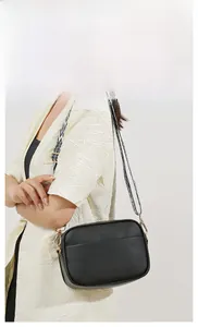 Detail of lychee pattern leather camera bag with black and white geometric wide strap