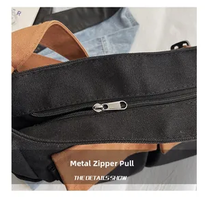 Detail of durable metal zipper slider on a two-tone black and brown canvas shoulder bag