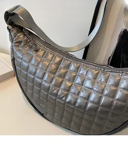 Detail view of the silver metallic quilted crescent bag with square stitching textures