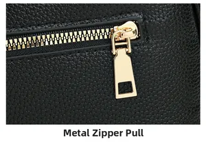 Detail of premium black pebble leather texture with golden hardware zipper puller