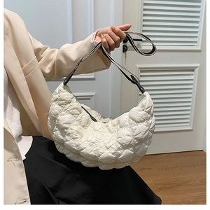 Dettaglio della borsa a mezzaluna trapuntata beige con trama a scacchi e tracolla jacquard