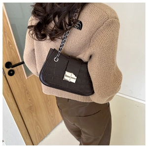 Detail of dark brown crocodile pattern PU leather shoulder bag with silver square clasp