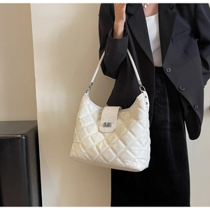 Close-up of white quilted PU leather hobo bag with silver metallic twist lock and strap