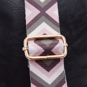 Close-up of geometric pattern shoulder strap with golden metal adjustable buckle on black bag